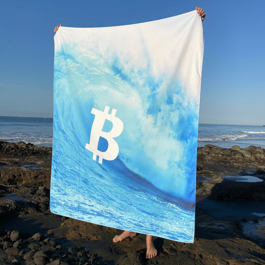 Blue and white flag with Bitcoin symbol on a rocky beach